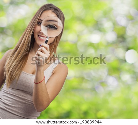 beautiful young woman looking through a magnifying glass
