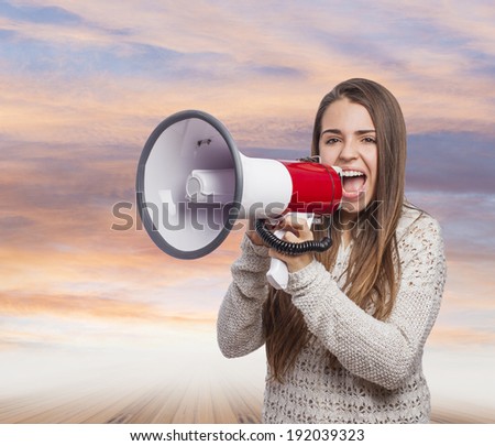 Angry young woman shouting with a megaphone