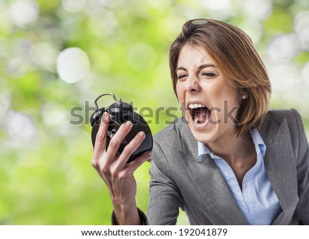 beautiful young business woman screaming to the alarm clock