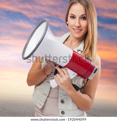 beautiful young woman holding and showing a megaphone