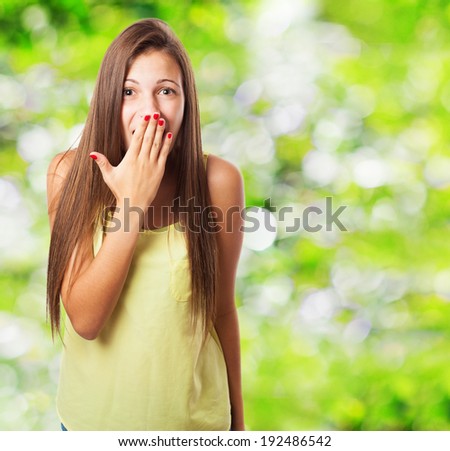 portrait of pretty young woman with her hand covering her mouth