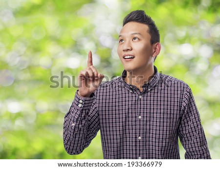 portrait of young asian man pointing up with finger
