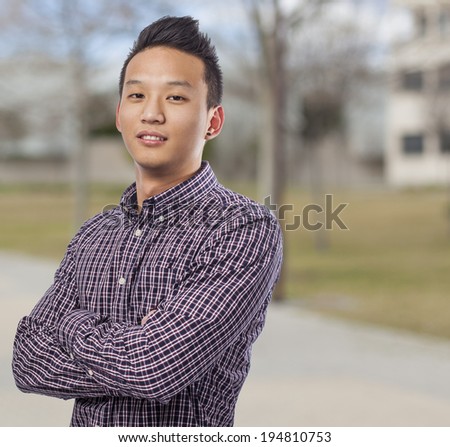 portrait of handsome young asian man at park