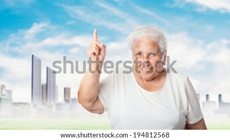 portrait of adorable old woman pointing up with her finger