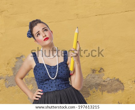 portrait of a pin up woman holding a big pencil