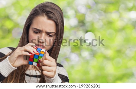 beautiful young woman concentrated solving the Rubik\'s Cube