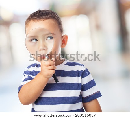 portrait of a cute kid looking through a magnifying glass