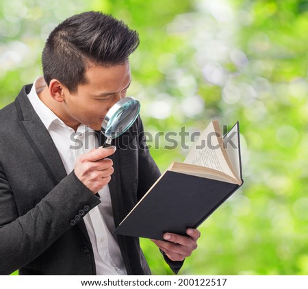 young business man looking through a magnifying glass