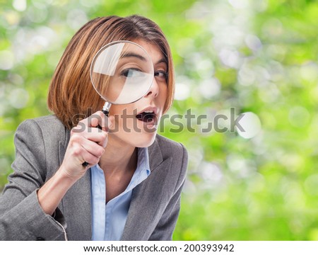 portrait of an executive young woman looking through a magnifying glass