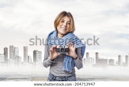 young woman holding a vintage camera at city
