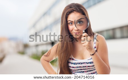 portrait of young woman looking through a magnifying glass