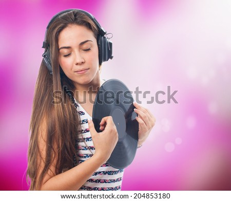 portrait of a young woman holding a vinyl and listening to music
