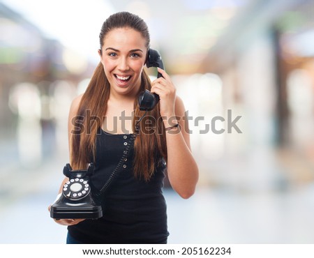 portrait of a young woman talking on a vintage telephone