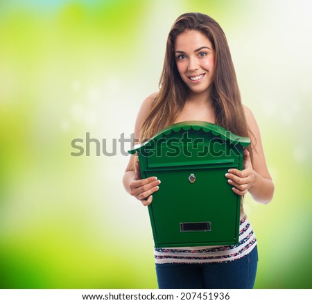 portrait of a young woman holding a green mailbox