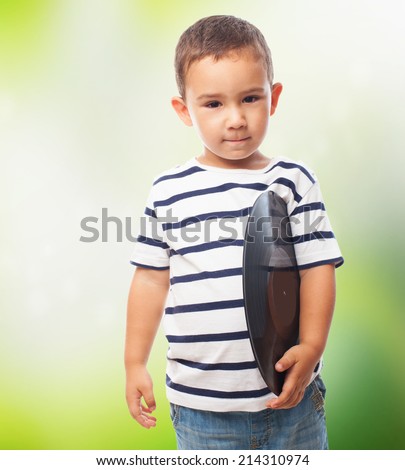 portrait of a little boy holding a vinyl record