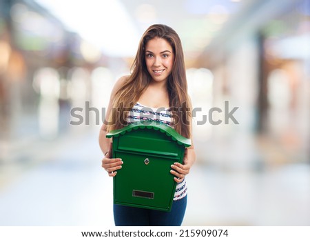 portrait of a girl holding a green mailbox