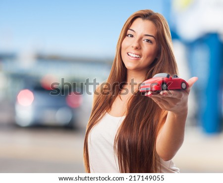 pretty young woman holding a red car toy