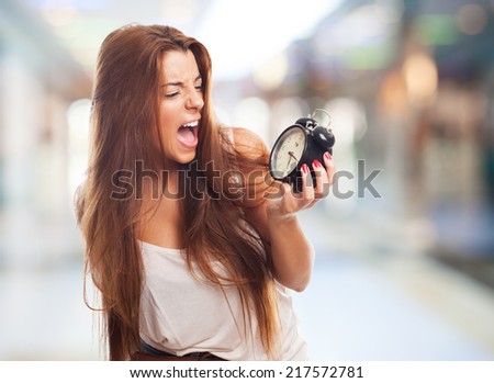 portrait of a young student screaming to alarm clock