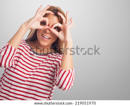 portrait of a beautiful young woman doing a glasses gesture