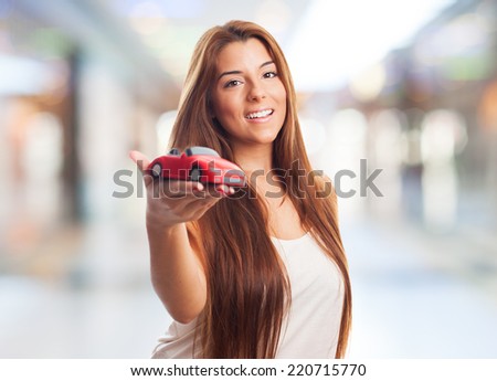 pretty young woman holding a red car toy