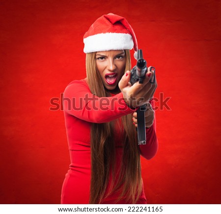 portrait of a beautiful young woman pointing a gun at Christmas