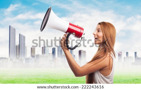 portrait of a beautiful young woman shouting through megaphone