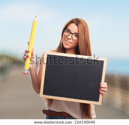 portrait of a pretty student holding a chalkboard and a pencil