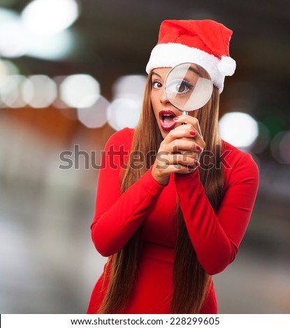 portrait of a beautiful young woman looking through the magnifying glass at Christmas