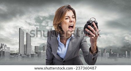 beautiful young business woman screaming to the alarm clock