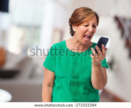 portrait of angry mature woman talking on telephone