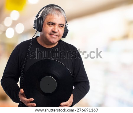 portrait of a mature man listening to music and holding a vinyl