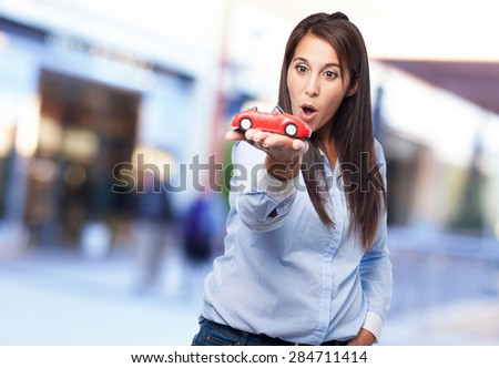 surprised young woman with red car