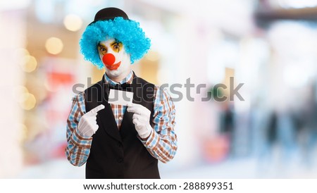 portrait of a funny clown showing a visit card