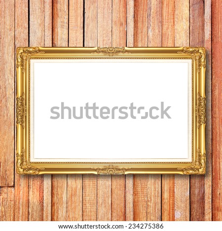Antique gold frame on wooden wall;. Empty  picture frame on wooden wall.