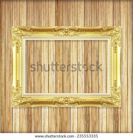 Antique gold frame on wooden wall ;. Empty picture frame on wooden wall.