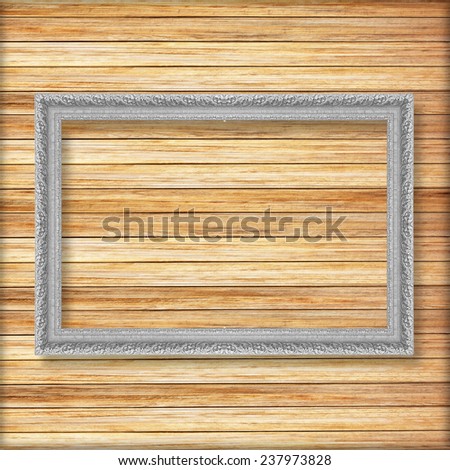 Antique silver frame on wooden wall ;. Empty picture frame on wooden wall.