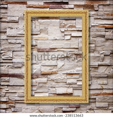Antique gold frame on stone wall background ,goldr picture frame on sandstone brick wall Surfaced background