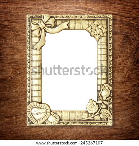 gold picture frame on wooden wall ;. Empty picture frame on wooden wall.