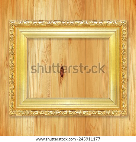 Antique gold frame on wooden wall;. Empty picture frame on wooden wall.