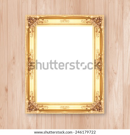 Antique gold frame on wooden wall;. Empty picture frame on wooden wall.
