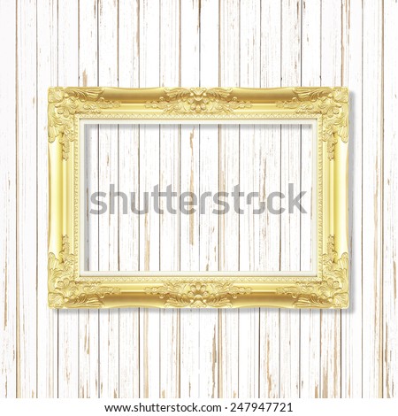 Antique gold frame on white wooden wall ;. Empty picture frame on wooden wall.
