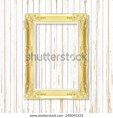 Antique gold frame on wooden wall ;. Empty picture frame on wooden wall.