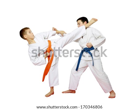Two athletes with orange and blue belts are doing paired karate exercises