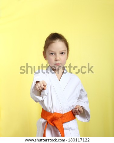 Girl on a yellow background with orange belt is hitting right hand