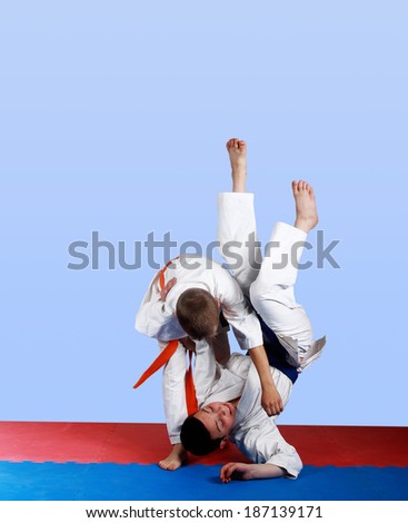 Boy with orange belt  done a throw judo