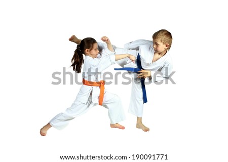 Girl and boy in karategi are training paired exercises karate