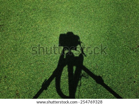 Shadow camera on background of grass.