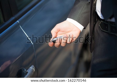 Male hand presses on the remote control car alarm systems