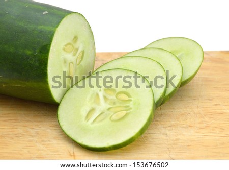 Sliced Cucumber in Stack on wooden board isolated on white