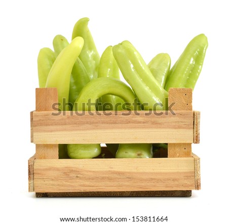 yellow banana peppers in wooden crater on white background.